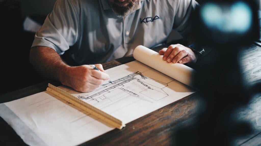 Man writing on construction plans