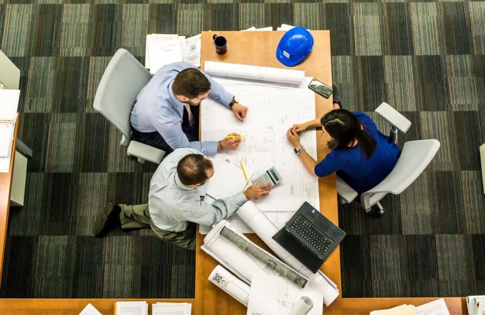 people sitting around desk working with view from above